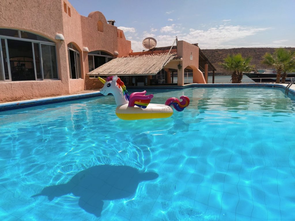 Alberca en Club Hotel Cantamar, La Paz, Baja California Sur, con un flotador inflable de unicornio